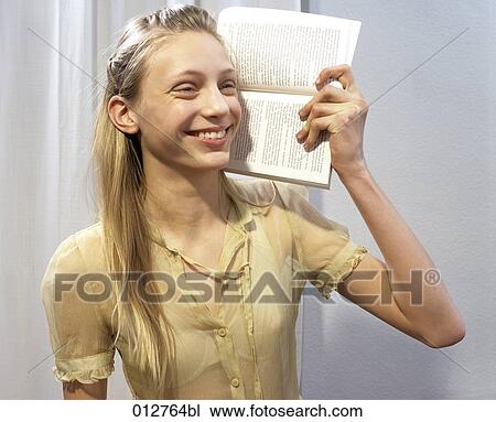 blonde teenage girl holding book to ear to signify an audio book View Large Photo Image Stock Image - blonde teenage girl holding book to ear to signify an audio book. Fotosearch