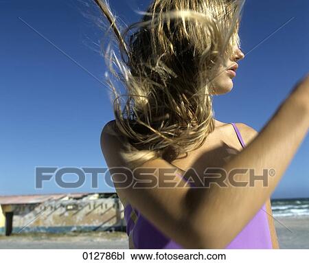 Stock Image - close-up of teenage girl on the beach with wind in her hair. Fotosearch