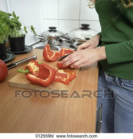 close-up of woman working in kitchen cutting red pepper View Large Photo Image Stock Image - close-up of woman working in kitchen cutting red pepper. Fotosearch