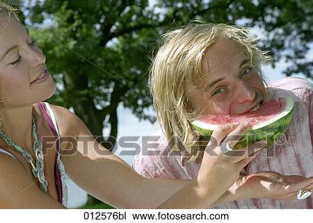 close-up of young woman feeding her boyfriend with watermelon View Large Photo Image Stock Image - close-up of young woman feeding her boyfriend with watermelon. Fotosearch
