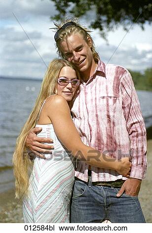 Stock Image - couple in summer clothes posing for a portrait at lakeside. Fotosearch