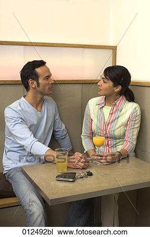 couple sitting in restaurant talking to each other View Large Photo Image Stock Image - couple sitting in restaurant talking to each other. Fotosearch