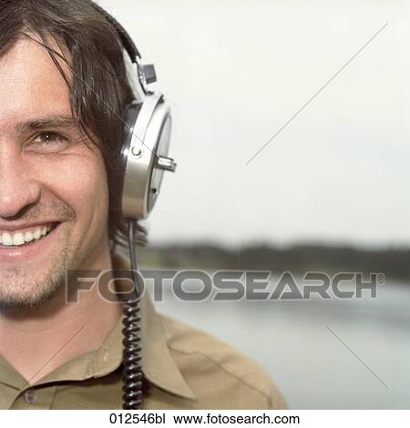 Stock Image - cropped portrait of young man with earphones. Fotosearch