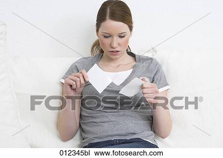 Stock Image - determined looking teenager girl ripping a photo. Fotosearch