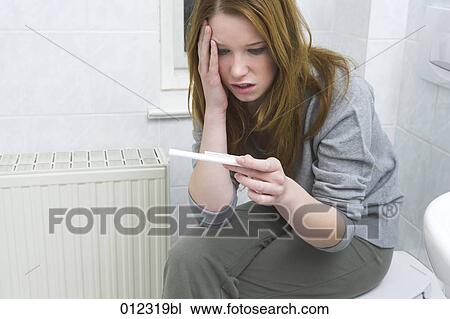 Stock Image - female teenager shocked by result of pregnancy test. Fotosearch