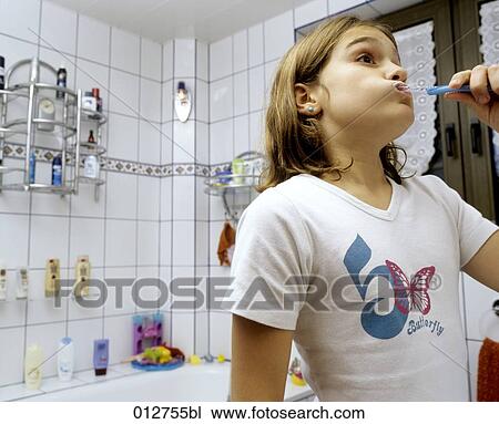 girl standing in bathroom brushing her teeth View Large Photo Image Stock Image - girl standing in bathroom brushing her teeth. Fotosearch