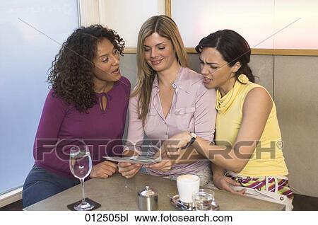 group of female friends looking at photos together View Large Photo Image Stock Image - group of female friends looking at photos together. Fotosearch