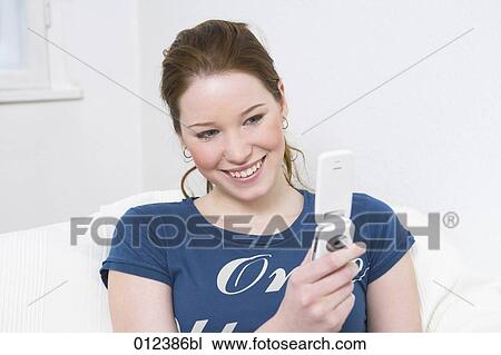happy young woman looking at her mobile View Large Photo Image Stock Image - happy young woman looking at her mobile. Fotosearch