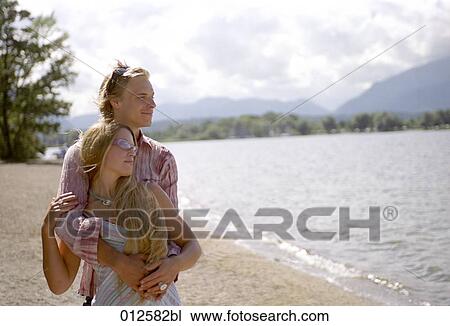 harmonious couple embracing and looking at lake View Large Photo Image Stock Image - harmonious couple embracing and looking at lake. Fotosearch