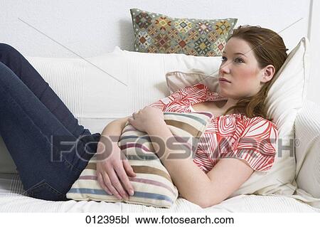 ill looking teenager on sofa holding cushion View Large Photo Image Stock Image - ill looking teenager on sofa holding cushion. Fotosearch