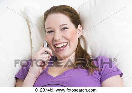Stock Image - laughing young woman talking on mobile phone. Fotosearch