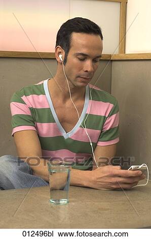man in sweater checking his ipod in cafe View Large Photo Image Stock Image - man in sweater checking his ipod in cafe. Fotosearch