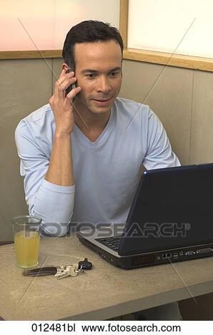 man sitting in restaurant working with laptop computer and talking on mobile View Large Photo Image Stock Image - man sitting in restaurant working with laptop computer and talking on mobile. Fotosearch