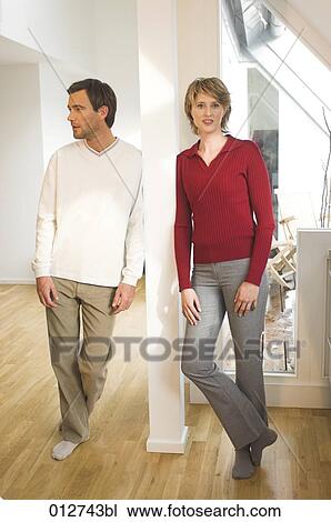Stock Image - mature couple leaning against pillar in their home . Fotosearch