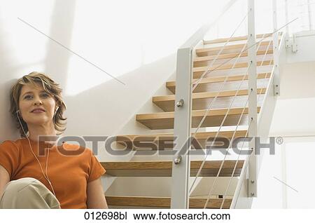 mature woman sitting on stairs listening to music View Large Photo Image Stock Image - mature woman sitting on stairs listening to music. Fotosearch