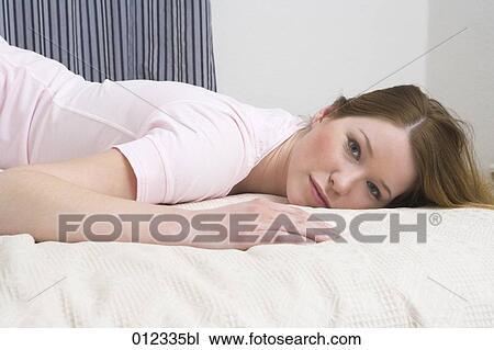 portrait of adolescent woman lying on bed View Large Photo Image Stock Image - portrait of adolescent woman lying on bed . Fotosearch