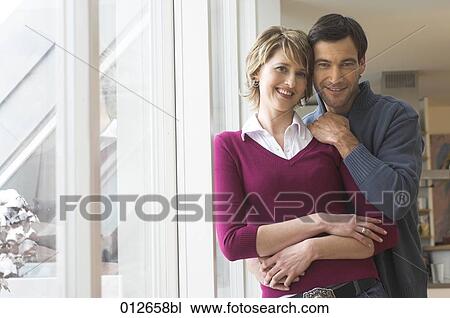 portrait of mature couple standing by the window View Large Photo Image Stock Image - portrait of mature couple standing by the window. Fotosearch