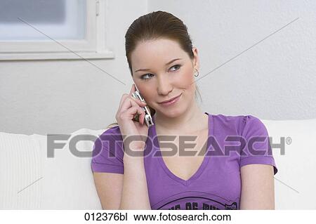 Stock Image - portrait of smiling young woman talking on cellphone. Fotosearch