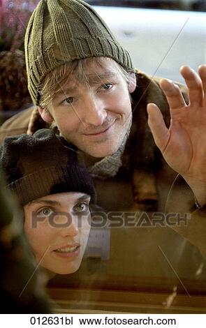 portrait of young couple looking through shop window at christmas time View Large Photo Image Stock Image - portrait of young couple looking through shop window at christmas time. Fotosearch