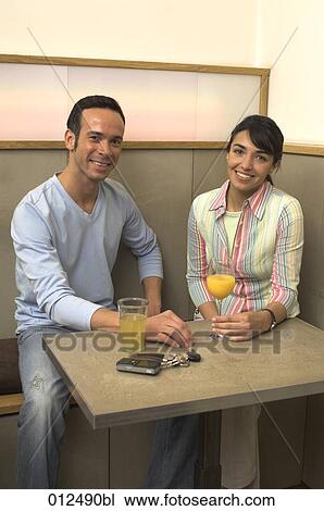 portrait of young man and woman sitting at a table in cafe View Large Photo Image Stock Image - portrait of young man and woman sitting at a table in cafe. Fotosearch