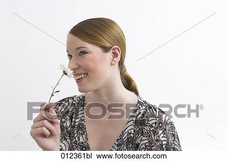 portrait of young woman holding flower View Large Photo Image Stock Image - portrait of young woman holding flower. Fotosearch