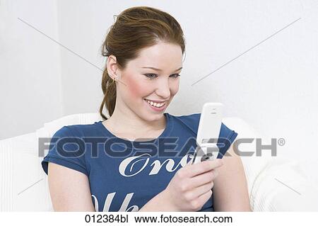portrait of young woman with red hairs holding mobile phone View Large Photo Image Stock Image - portrait of young woman with red hairs holding mobile phone. Fotosearch