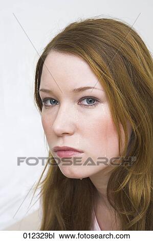 Stock Image - sad looking female teenager with long red hairs. Fotosearch