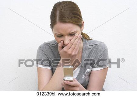 shocked woman looking at display of her mobile View Large Photo Image Stock Image - shocked woman looking at display of her mobile. Fotosearch