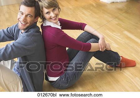 smiling couple sitting on the floor of their home View Large Photo Image Stock Image - smiling couple sitting on the floor of their home. Fotosearch