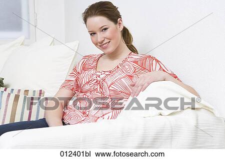 smiling teenage girl sitting comfortably on sofa View Large Photo Image Stock Image - smiling teenage girl sitting comfortably on sofa. Fotosearch
