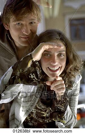 smiling woman looking through shop window pointing at display View Large Photo Image Stock Image - smiling woman looking through shop window pointing at display. Fotosearch