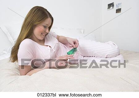 smiling young woman looking at photograph View Large Photo Image Stock Image - smiling young woman looking at photograph. Fotosearch