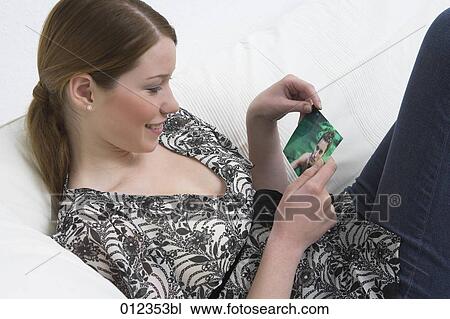 smiling young woman looking photograph of her boyfriend View Large Photo Image Stock Image - smiling young woman looking photograph of her boyfriend. Fotosearch