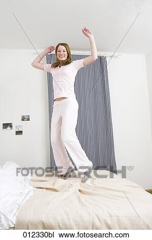 teenage girl jumping on her bed View Large Photo Image Stock Image - teenage girl jumping on her bed. Fotosearch