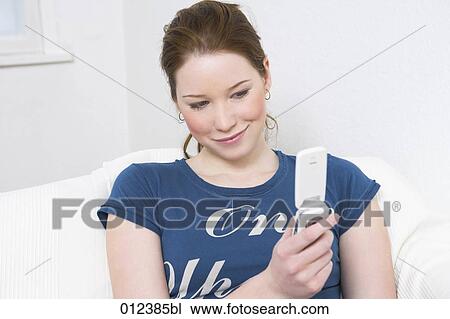 teenage girl looking at display of her mobile with a mischievous smile View Large Photo Image Stock Image - teenage girl looking at display of her mobile with a mischievous smile. Fotosearch