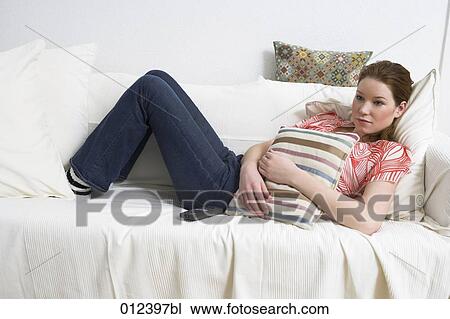 teenage with melancholic expression lying on couch and watching tv View Large Photo Image Stock Image - teenage with melancholic expression lying on couch and watching tv. Fotosearch
