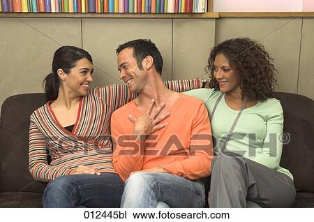 three friends smiling together on sofa View Large Photo Image Stock Image - three friends smiling together on sofa. Fotosearch