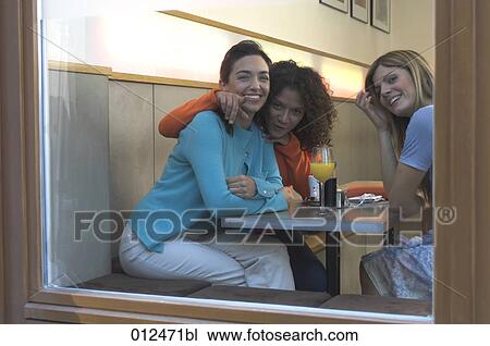 three young women sitting by the window in cafe View Large Photo Image Stock Image - three young women sitting by the window in cafe. Fotosearch