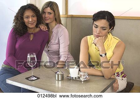three young women sitting in cafe one looking enervated View Large Photo Image Stock Image - three young women sitting in cafe one looking enervated. Fotosearch