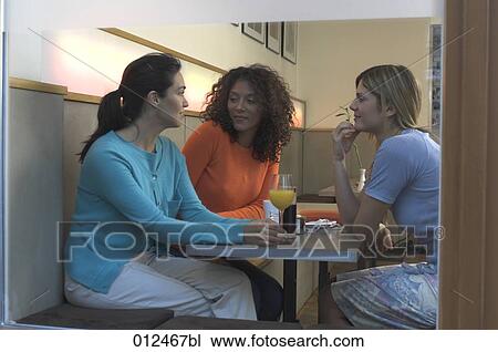 three young women sitting in cafe seen through window View Large Photo Image Stock Image - three young women sitting in cafe seen through window. Fotosearch
