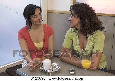 two good friends sitting in cafe and having a conversation View Large Photo Image Stock Image - two good friends sitting in cafe and having a conversation. Fotosearch