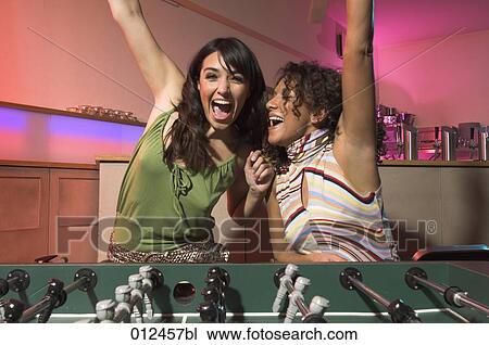 two women friends celebrating win in foosball match View Large Photo Image Stock Image - two women friends celebrating win in foosball match. Fotosearch