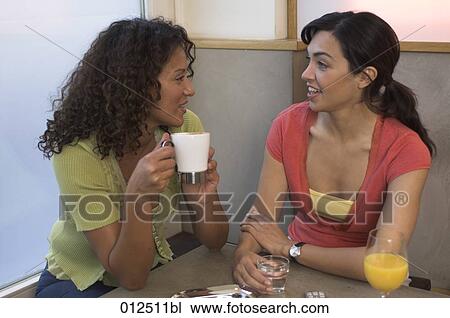 two young women drinking coffee and having a conversation View Large Photo Image Stock Image - two young women drinking coffee and having a conversation. Fotosearch