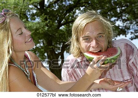 young couple having fun eating a slice of melon View Large Photo Image Stock Image - young couple having fun eating a slice of melon. Fotosearch