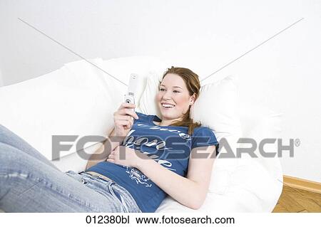 young girl lying of sofa playing with mobile phone View Large Photo Image Stock Image - young girl lying of sofa playing with mobile phone. Fotosearch