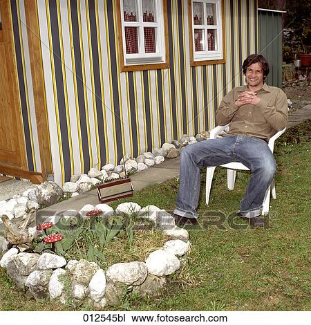 young man relaxing in front of small hut View Large Photo Image Stock Image - young man relaxing in front of small hut. Fotosearch