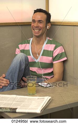 young man showing a happy face in cafe with ipod by his side View Large Photo Image Stock Image - young man showing a happy face in cafe with ipod by his side. Fotosearch