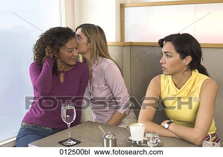 young woman looking suspiciously at two friends whispering View Large Photo Image Stock Image - young woman looking suspiciously at two friends whispering . Fotosearch