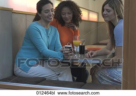 young woman showing ipod to her friends in cafe View Large Photo Image Stock Image - young woman showing ipod to her friends in cafe. Fotosearch
