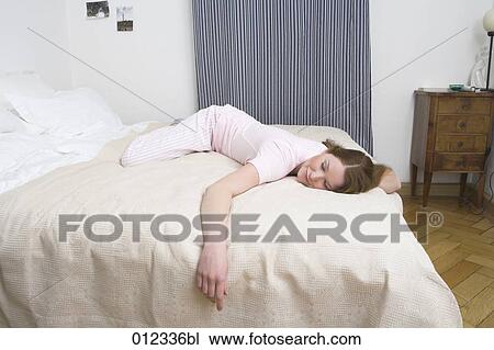 Stock Image - young woman sleeping with a smile on her face. Fotosearch